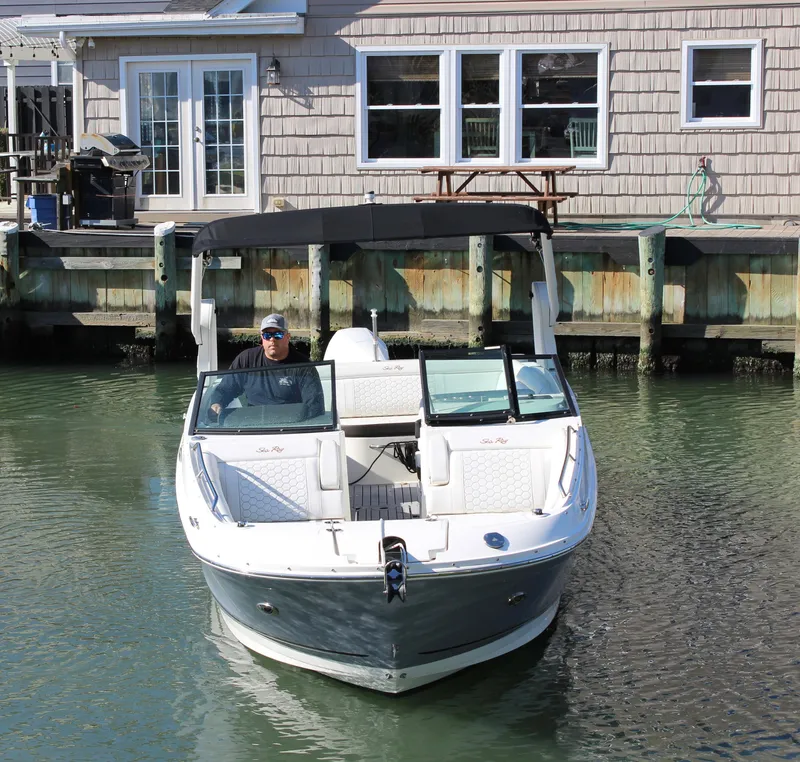 Slide: The Image of 2020 Sea Ray SDX 270 OB boat docked near a waterfront house. - 19