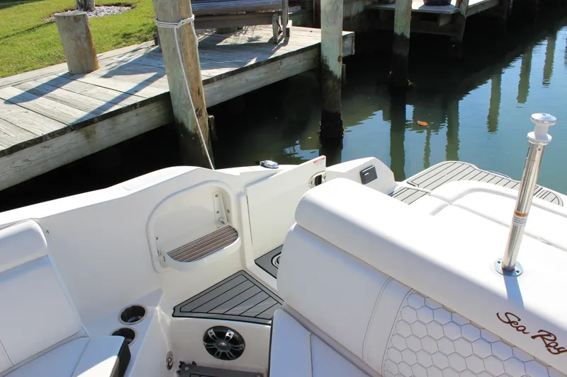 Slide: The Image of 2020 Sea Ray SDX 270 OB boat interior near dock, featuring seating and speaker. - 28