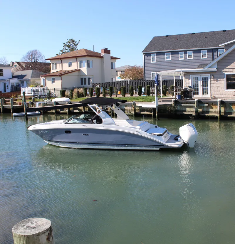 Slide: The Image of 2020 Sea Ray SDX 270 OB boat docked in a residential canal setting. - 7