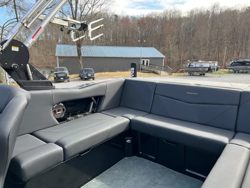 Slide: The Image of 2020 MasterCraft NXT22 boat interior with gray seating and wakeboard rack. - 10