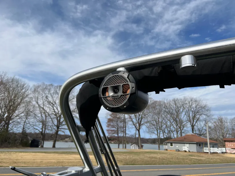 Slide: The Image of 2020 MasterCraft NXT22 boat with mounted speaker, clear sky, and lake view. - 13