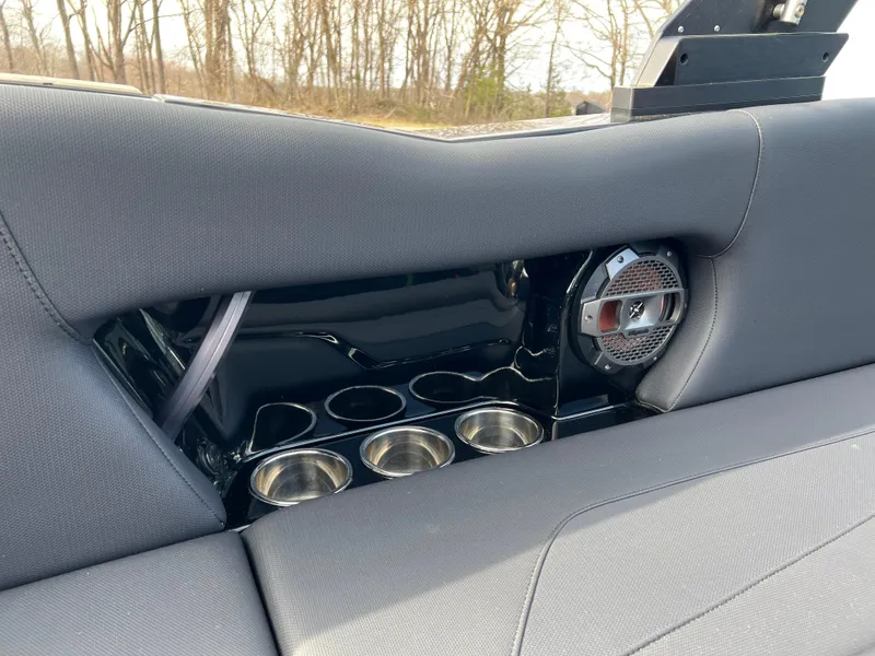 Slide: The Image of 2020 MasterCraft NXT22 boat interior with cup holders and speaker, featuring sleek gray upholstery. - 14
