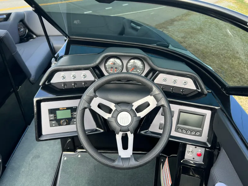 Slide: The Image of 2020 MasterCraft NXT22 boat dashboard with steering wheel and control panels. - 6