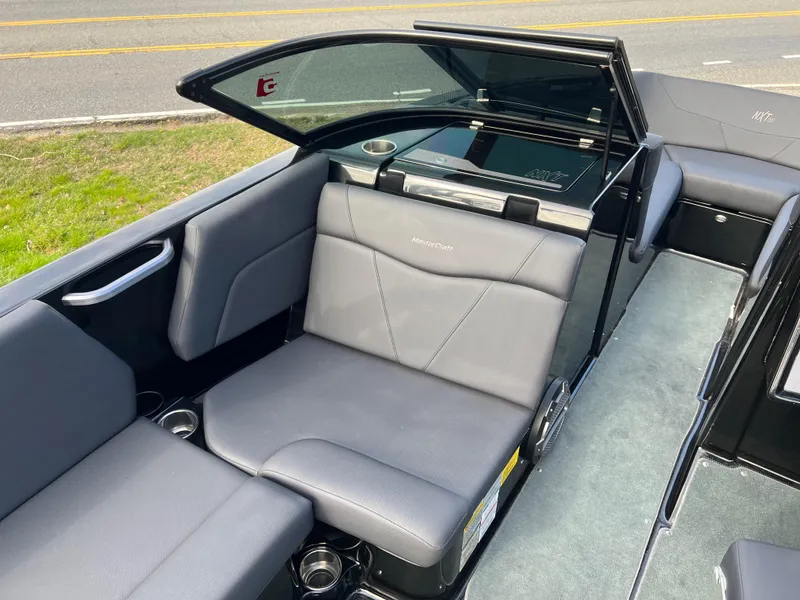 Slide: The Image of 2020 MasterCraft NXT22 boat interior with gray seating and open windshield. - 8