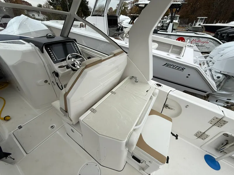 Slide: The Image of 2018 Edgewater 262 CX boat interior with helm, seating, and storage compartments. - 10