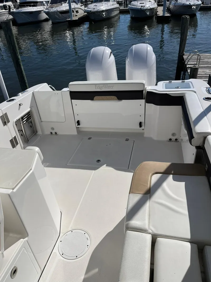 Slide: The Image of 2018 Edgewater 262 CX boat interior with seating, docked at marina. - 14