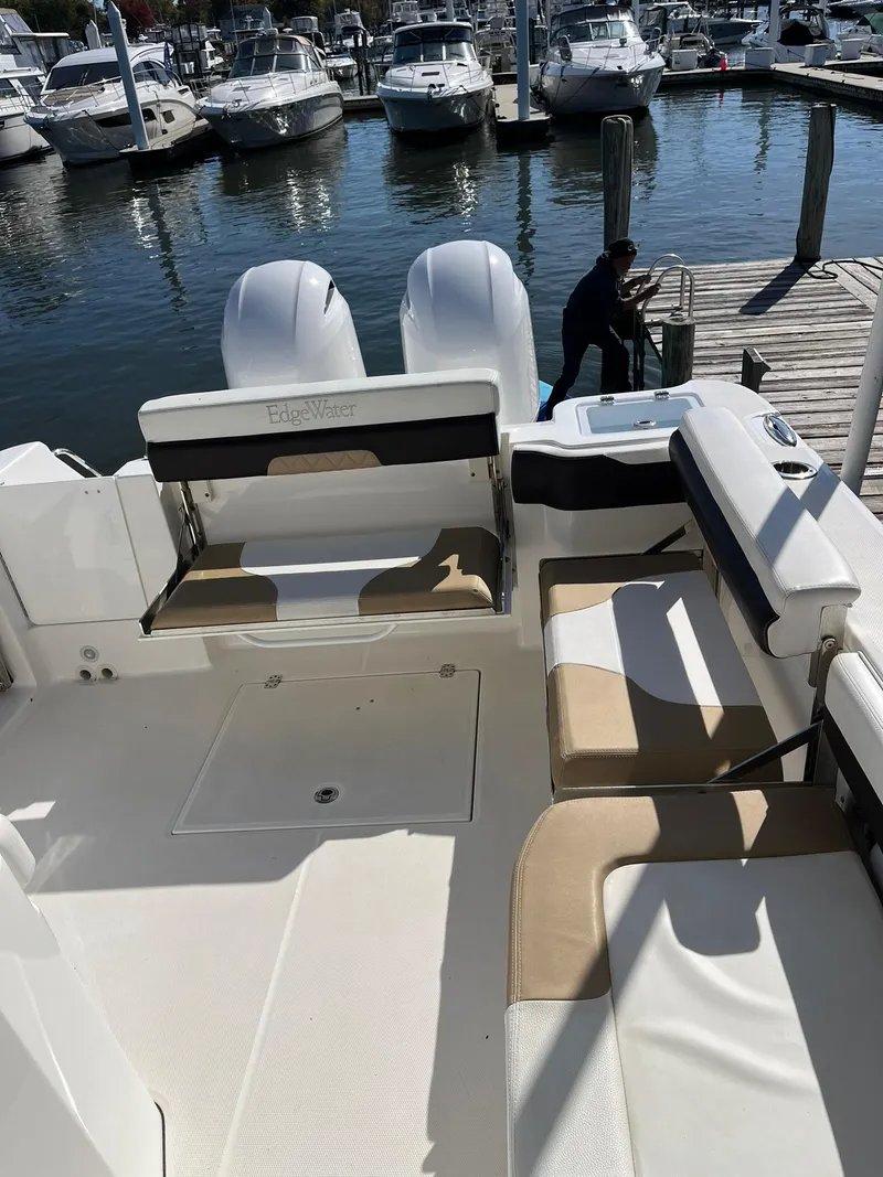 Slide: The Image of 2018 Edgewater 262 CX boat interior with seating, docked at a marina. - 19
