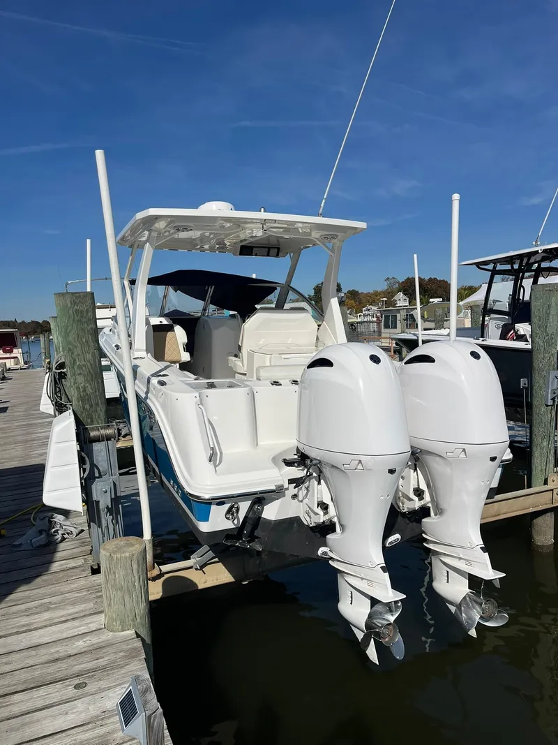 Slide: The Image of 2018 Edgewater 262 CX boat docked with dual outboard motors. - 21