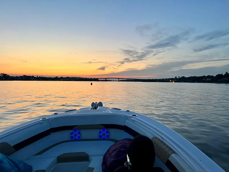 Slide: The Image of 2018 Edgewater 262 CX boat cruising at sunset on calm waters. - 23