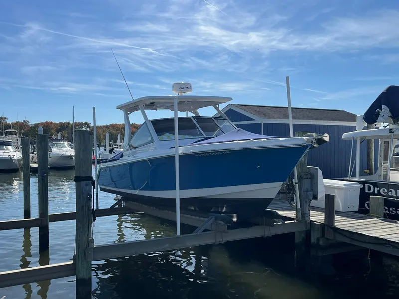 Slide: The Image of 2018 Edgewater 262 CX boat docked at a marina under a clear blue sky. - 4