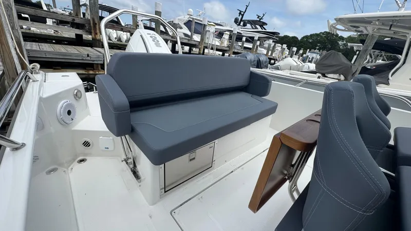 Slide: The Image of 2024 Nimbus T8 boat with gray seating, docked at a marina. - 10