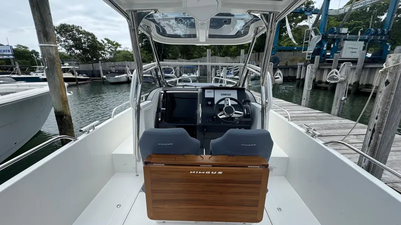Slide: The Image of 2024 Nimbus T8 boat interior with steering wheel and dashboard at a marina. - 12