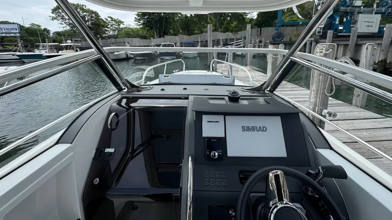 Slide: The Image of 2024 Nimbus T8 boat dashboard with Simrad navigation system, docked at a marina. - 13