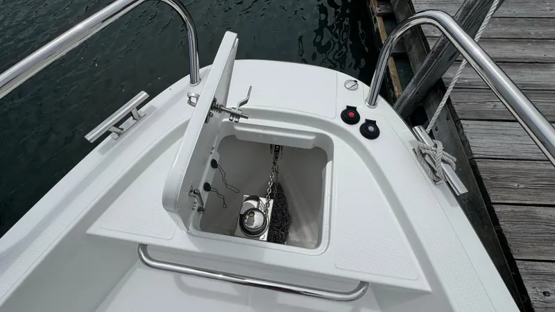 Slide: The Image of 2024 Nimbus T8 boat anchor compartment with open hatch, dockside view. - 26