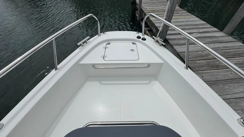 Slide: The Image of 2024 Nimbus T8 boat bow with sleek design, docked by wooden pier. - 27