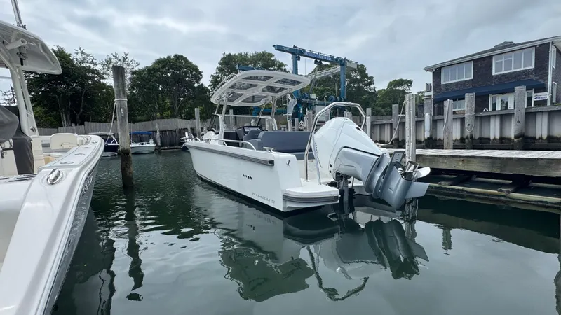 Slide: The Image of 2024 Nimbus T8 boat docked in a marina, overcast sky, calm water reflections. - 3