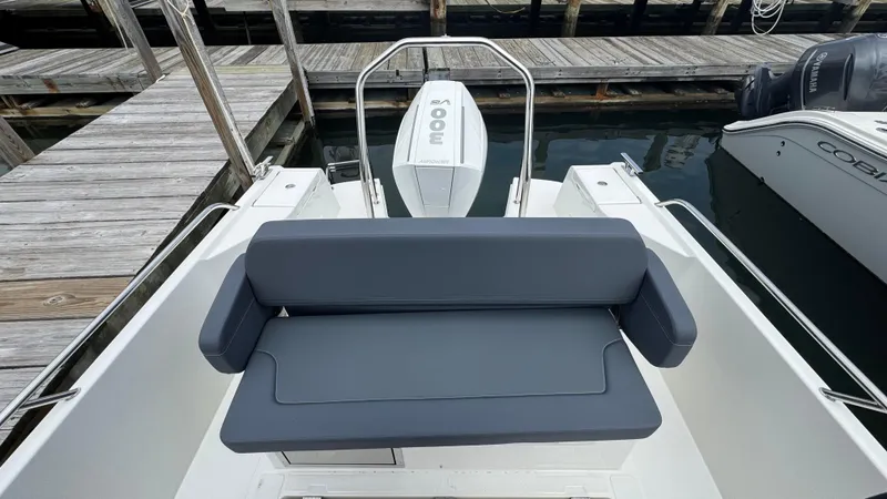 Slide: The Image of 2024 Nimbus T8 boat with cushioned seating and outboard motor at dock. - 9