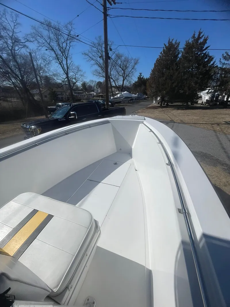 Slide: The Image of 1998 Contender 21 CC boat, repowered in 2018, parked outdoors on a sunny day. - 14