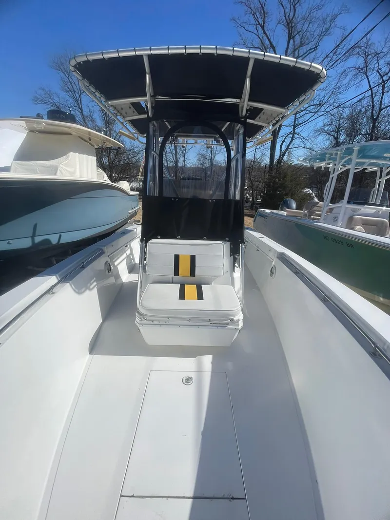 Slide: The Image of 1998 Contender 21 CC boat with T-top and seating, repowered in 2018, docked outdoors. - 15