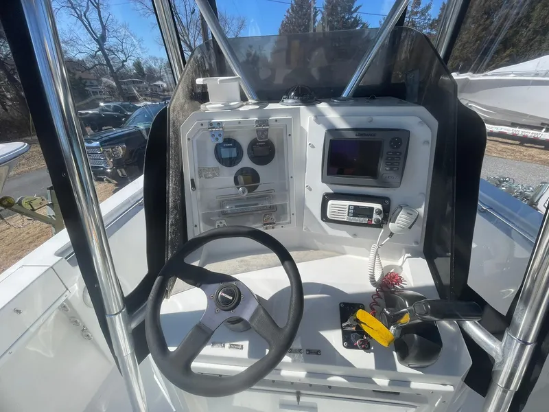 Slide: The Image of Center console of a 1998 Contender 21 CC boat, repowered in 2018, with steering wheel and controls. - 17