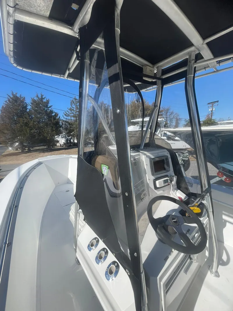 Slide: The Image of 1998 Contender 21 CC boat cockpit with modern controls, repowered in 2018, under clear blue sky. - 19