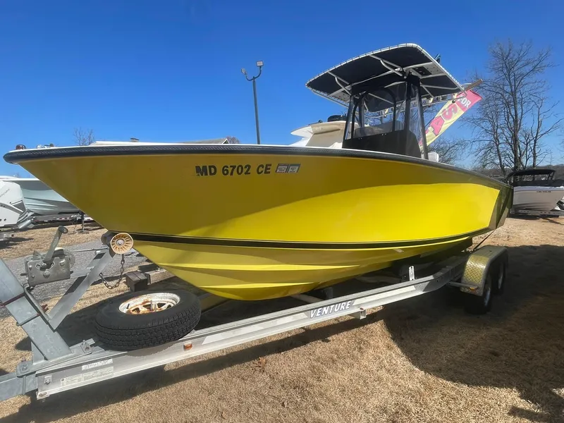 Slide: The Image of Yellow 1998 Contender 21 CC boat on trailer, repowered in 2018, under clear blue sky. - 2
