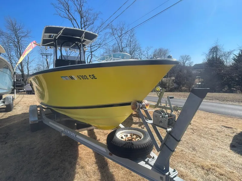Slide: The Image of Yellow 1998 Contender 21 CC boat on trailer, repowered in 2018, parked outdoors. - 3