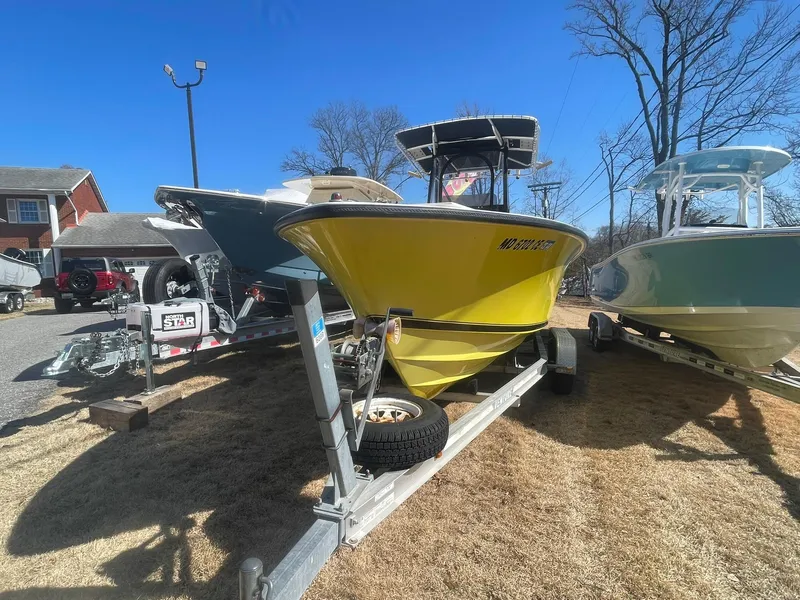 Slide: The Image of Yellow 1998 Contender 21 CC boat on trailer, repowered in 2018, parked outdoors. - 4