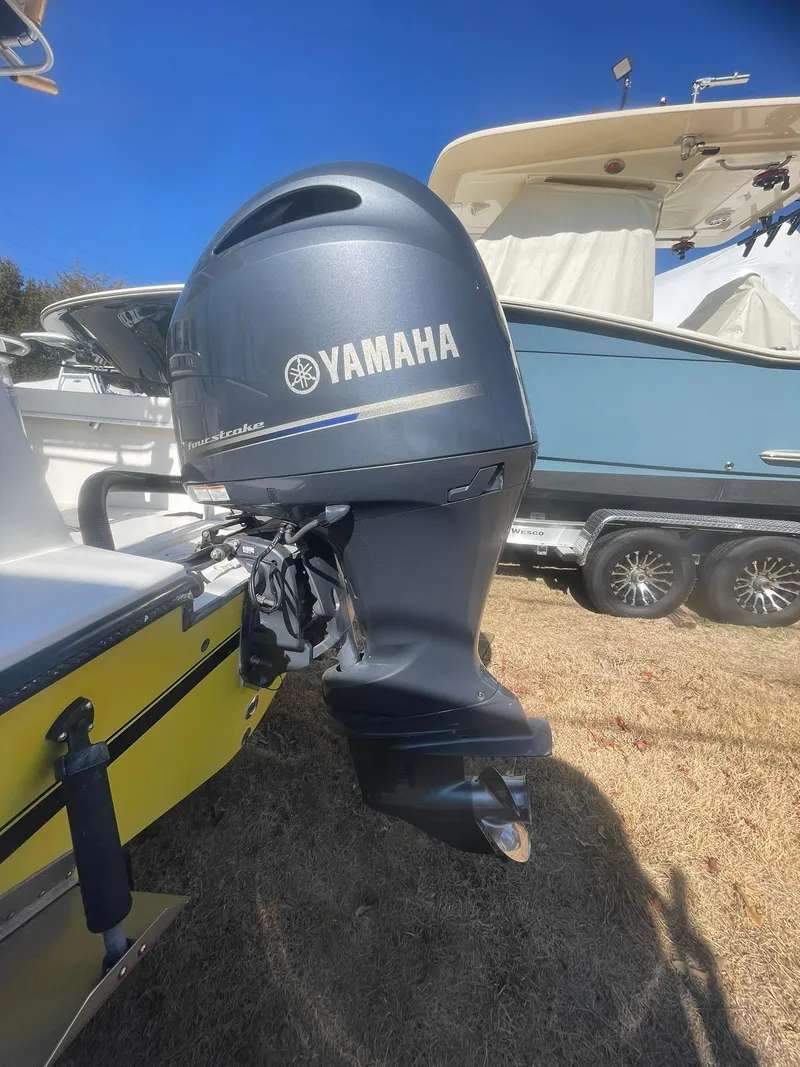 Slide: The Image of 1998 Contender 21 CC boat with Yamaha outboard motor, repowered in 2018, parked on grass. - 8