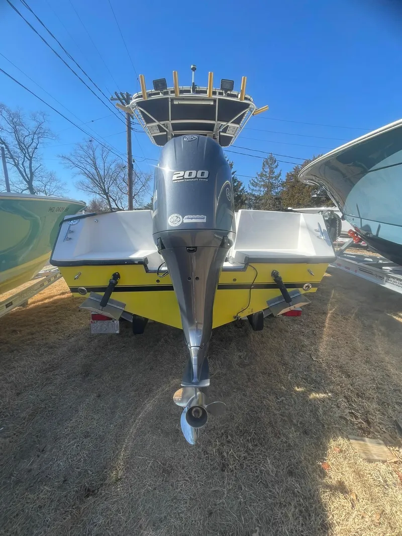 Slide: The Image of Yellow 1998 Contender 21 CC boat with 200 HP engine, repowered in 2018, parked outdoors. - 9