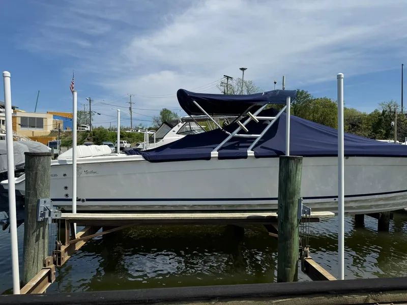 Slide: The Image of 2006 Marlago FS35 boat docked with blue cover, sunny day, marina background. - 10