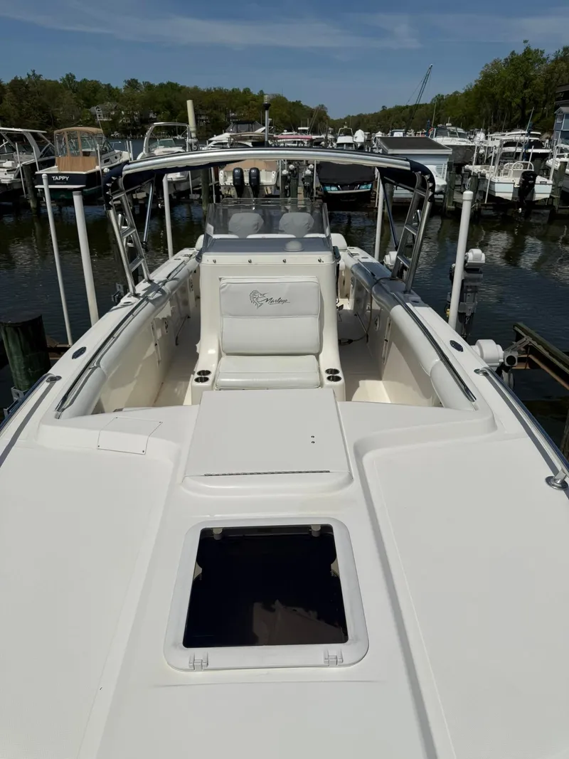 Slide: The Image of 2006 Marlago FS35 boat docked in a marina, showcasing spacious deck and seating. - 15