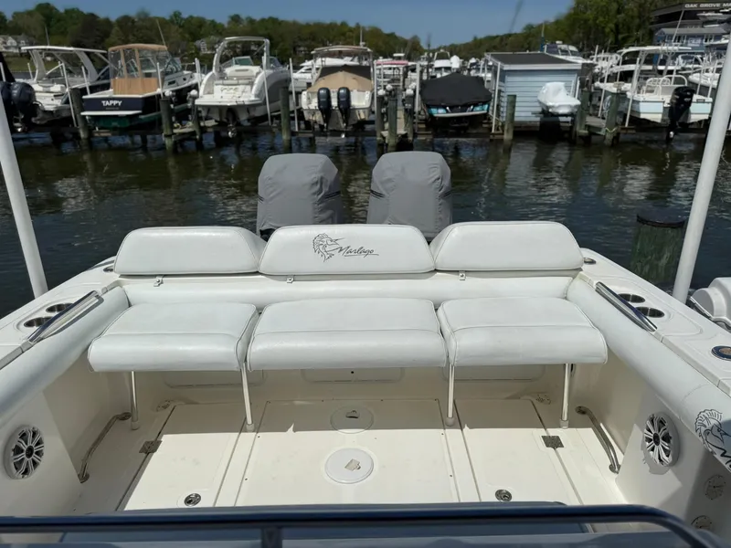 Slide: The Image of 2006 Marlago FS35 boat with white seating, docked at a marina with multiple boats. - 18