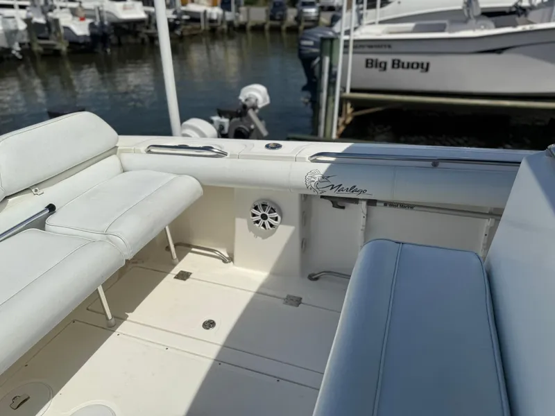 Slide: The Image of 2006 Marlago FS35 boat interior with white seating, docked near other boats. - 23