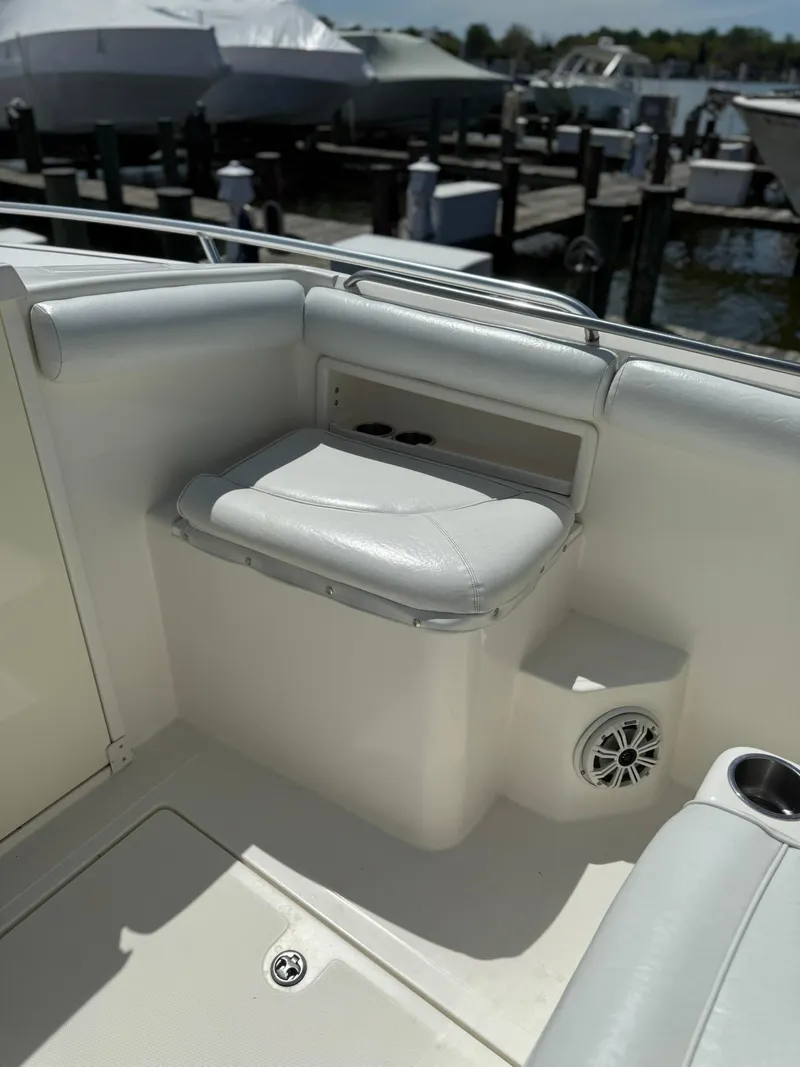 Slide: The Image of 2006 Marlago FS35 boat interior with cushioned seating and speaker, docked at marina. - 24