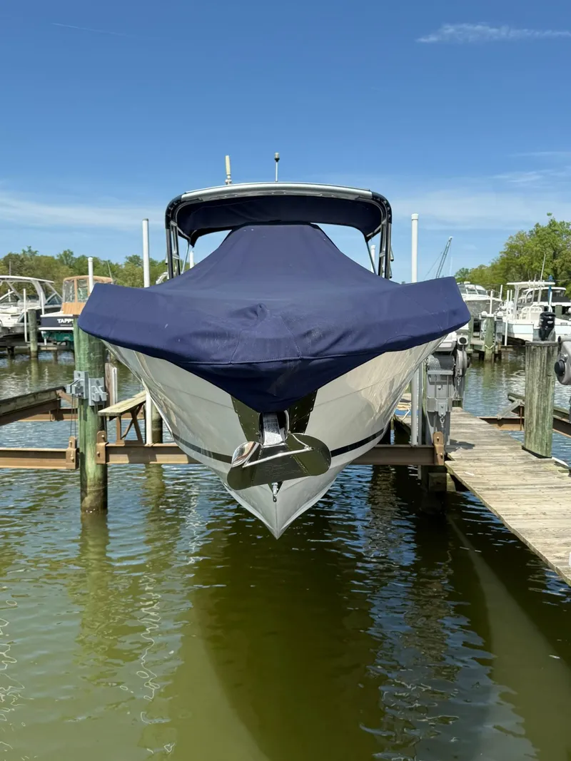 Slide: The Image of 2006 Marlago FS35 boat docked with cover, front view, in a marina setting. - 7