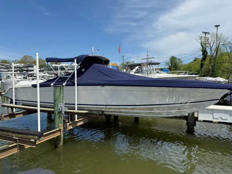 Slide: The Image of 2006 Marlago FS35 boat with blue cover docked on a sunny day. - 9