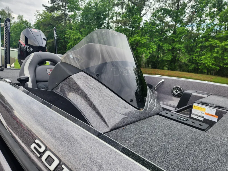 Slide: The Image of 2021 Triton 20 TRX boat with sleek design, windshield, and powerful engine, set against a forest backdrop. - 11