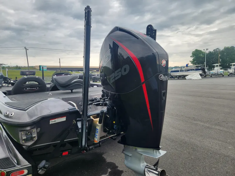 Slide: The Image of 2021 Triton 20 TRX boat with powerful outboard motor in a parking lot. - 3