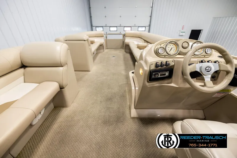 Slide: The Image of 2006 Sylvan 8524 Mirage RE boat interior with beige seating and steering console. - 17