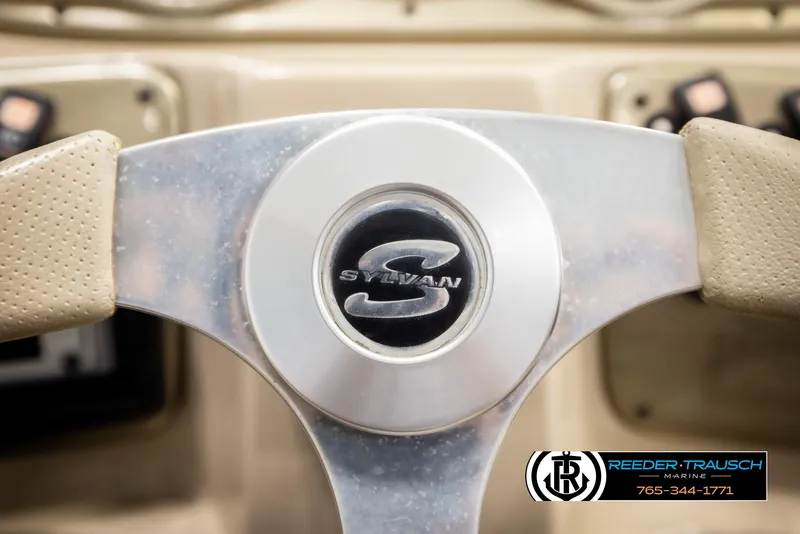 Slide: The Image of Steering wheel of 2006 Sylvan 8524 Mirage RE boat, featuring logo and beige interior. - 31