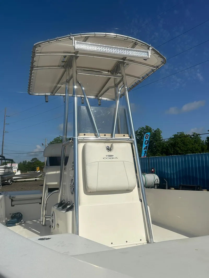 Slide: The Image of 2021 Cobia 21 Bay boat with T-top under clear blue sky. - 10