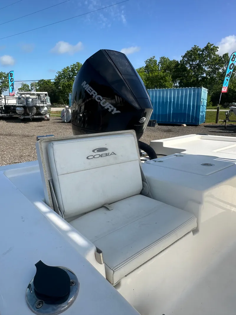 Slide: The Image of 2021 Cobia 21 Bay boat with Mercury engine, white seating, and outdoor setting. - 12