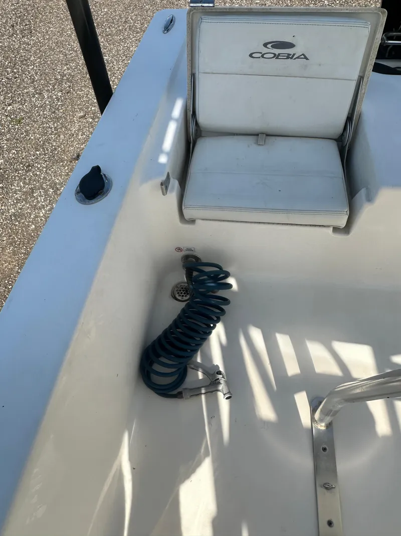 Slide: The Image of 2021 Cobia 21 Bay boat interior with seat and coiled hose. - 15