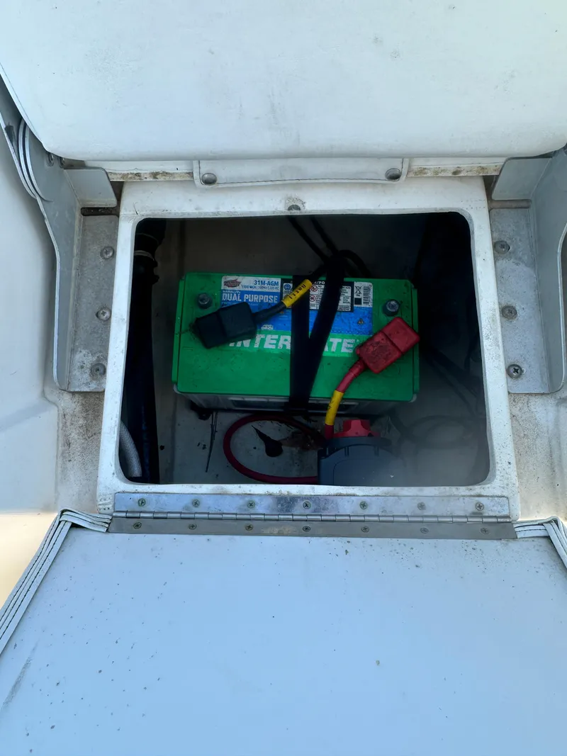 Slide: The Image of Battery compartment of a 2021 Cobia 21 Bay boat, featuring an Interstate battery. - 16