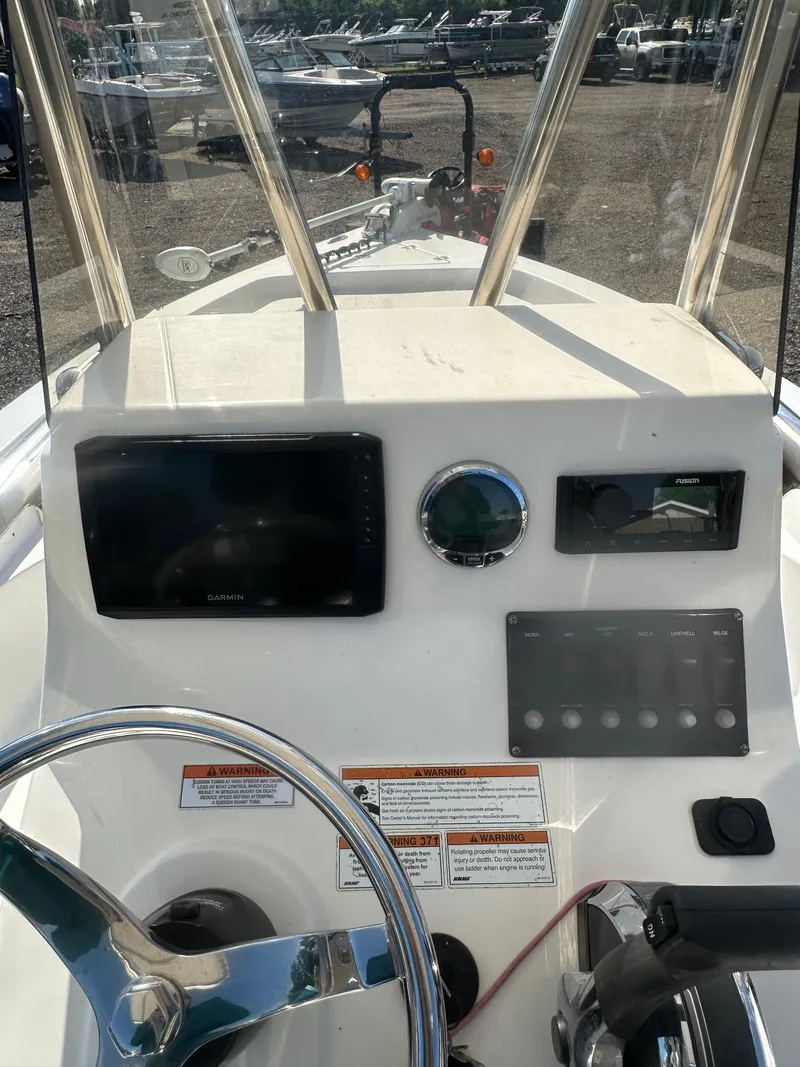 Slide: The Image of 2021 Cobia 21 Bay boat dashboard with steering wheel and navigation controls. - 19