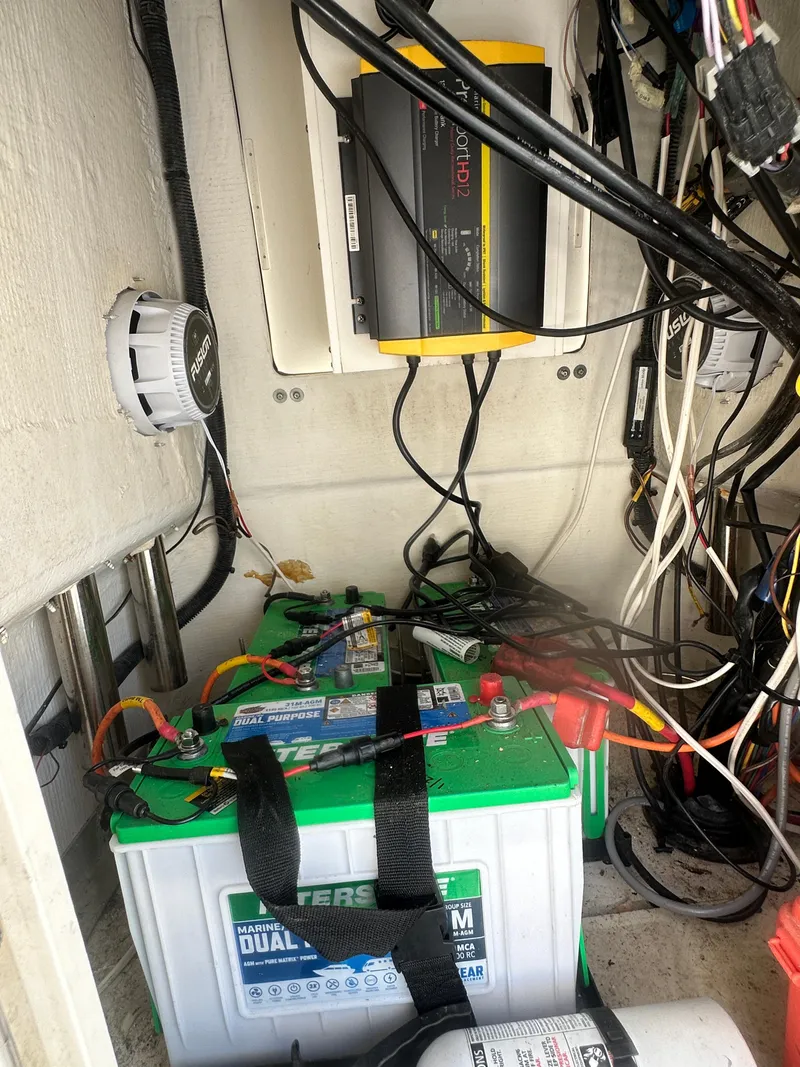 Slide: The Image of 2021 Cobia 21 Bay boat battery compartment with wiring and charger. - 20