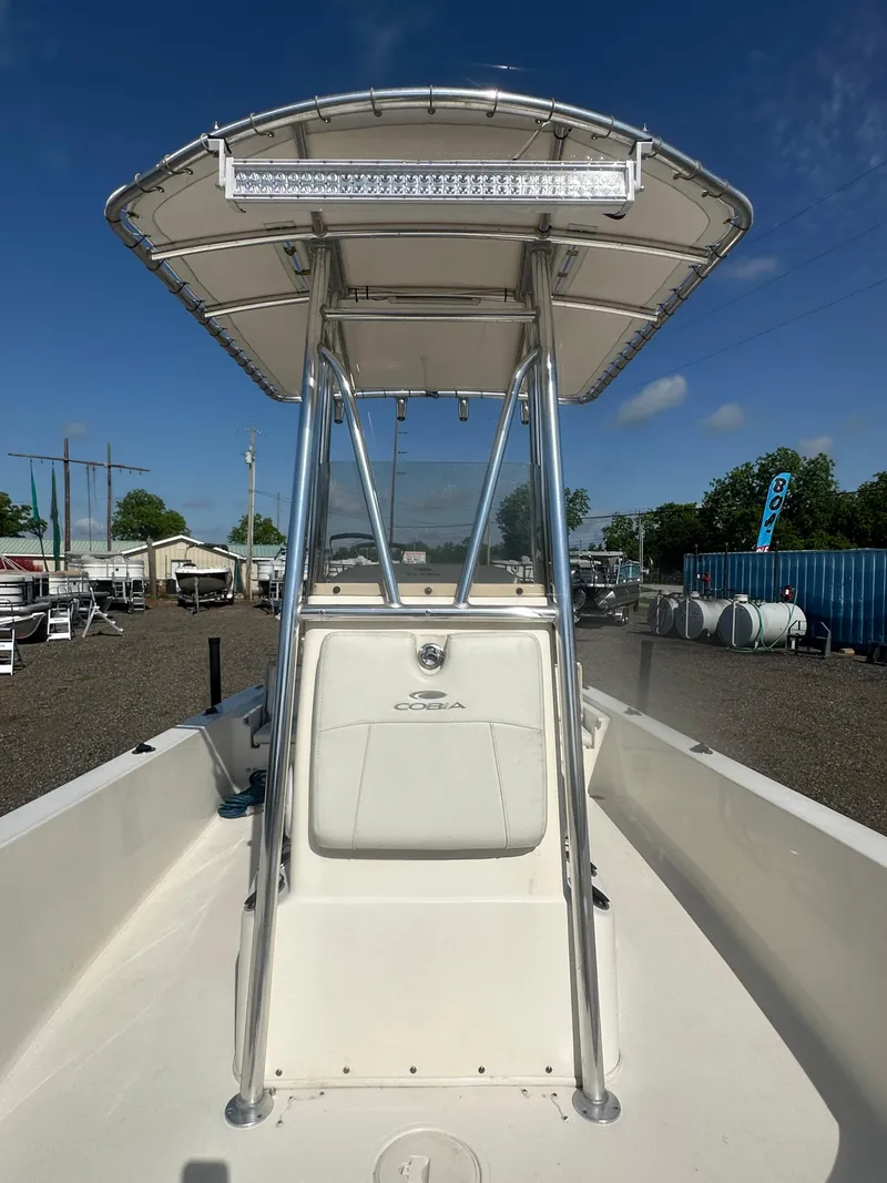 Slide: The Image of 2021 Cobia 21 Bay boat with T-top, viewed from the bow, in a marina setting. - 22