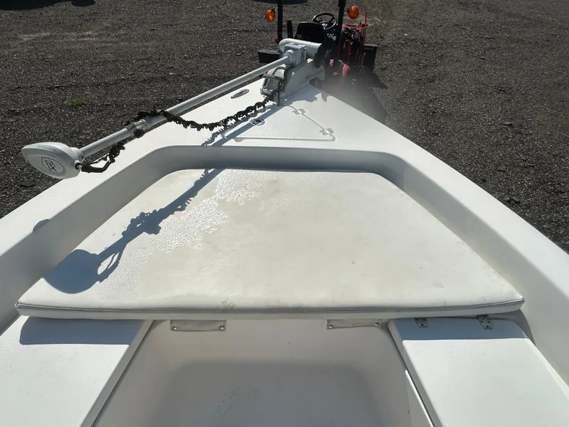 Slide: The Image of 2021 Cobia 21 Bay boat deck with trolling motor, parked on gravel. - 25