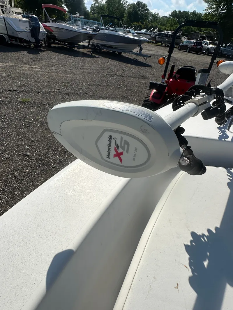 Slide: The Image of 2021 Cobia 21 Bay boat with Minn Kota trolling motor in a marina setting. - 26